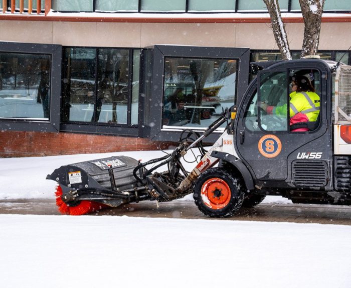 Bobcat machine clearing snow in front of Schine